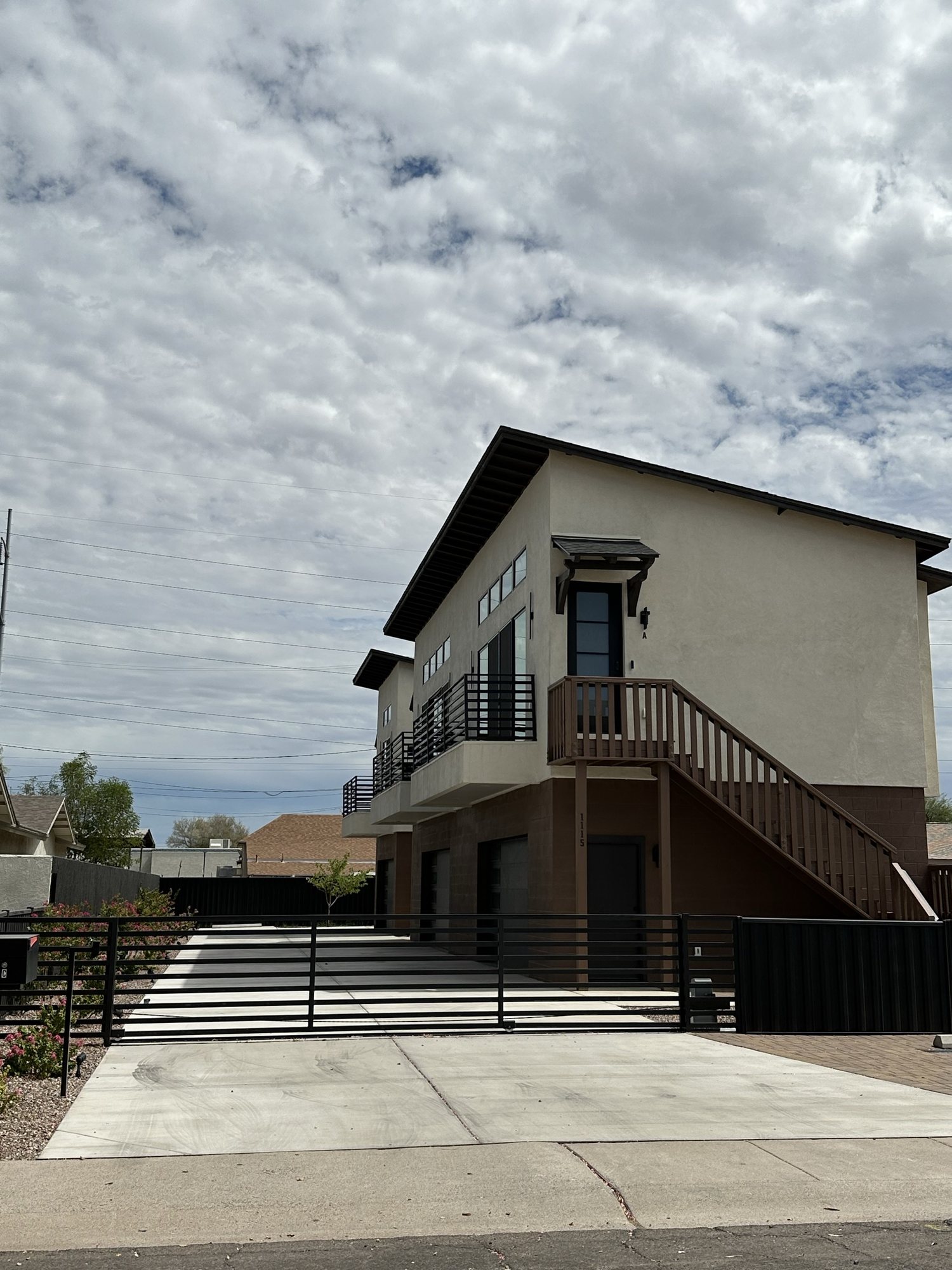 The Valley Heights triplex behind its gated motor court on a cloud-filled Phoenix afternoon
