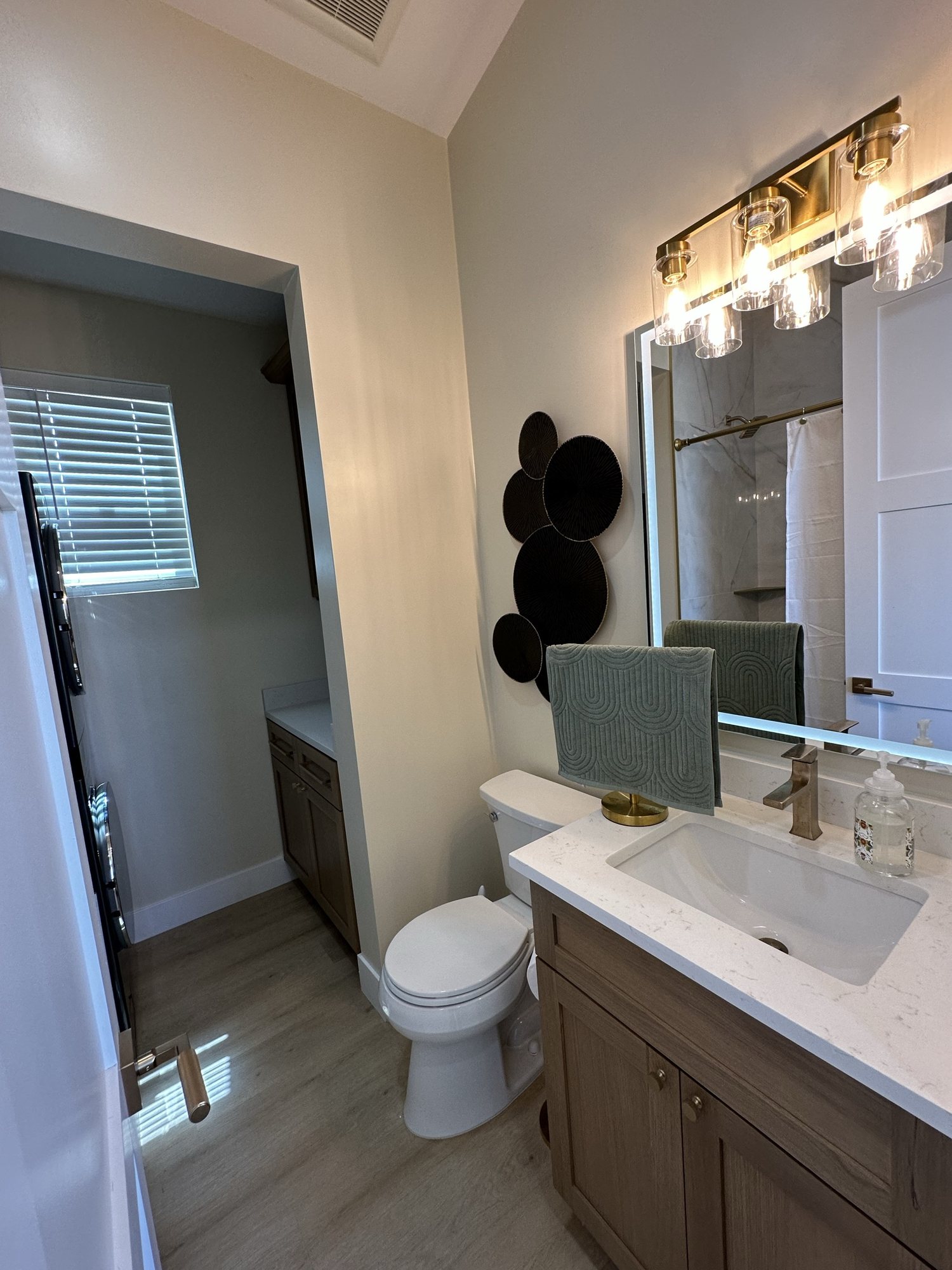 Bathroom vanity with backlit mirror and quartz counter
